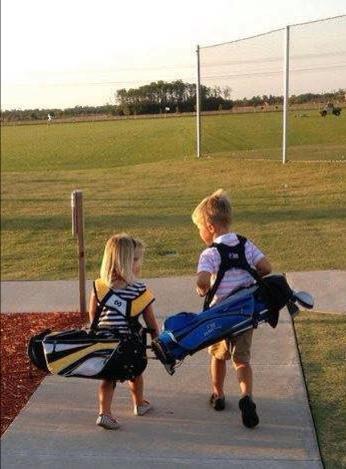two children carrying golf bags