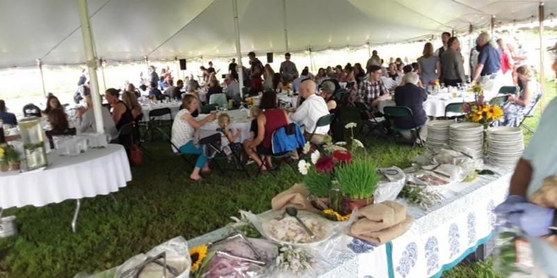 outdoor pavilion tent with people eating at tables